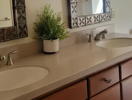 bathroom-beige-countertop-routine-cleaned Clean and tidy bathroom counter with two sinks.