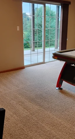 Freshly vacuumed carpet in a game room with an air hockey table in the middle of the floor.
