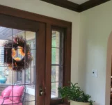 Tidy entrance to a home with a dark wooden and glass door.