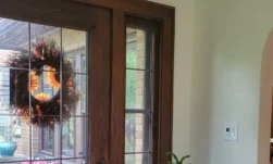 Tidy entrance to a home with a dark wooden and glass door.