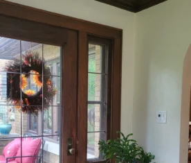 Tidy entrance to a home with a dark wooden and glass door.