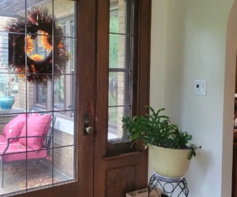 Tidy entrance to a home with a dark wooden and glass door.