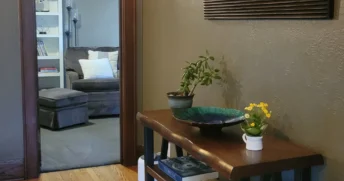 Clean and tidy hallway with a wooden floor leading to a small reading room.