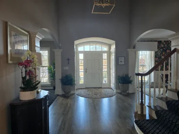 Tidy and clean entrance to a large home with a white door after a routine clean.