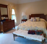 Tidy and clean bedroom with a freshly vacuumed carpet after a routine clean.