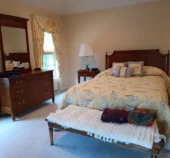 Tidy and clean bedroom with a freshly vacuumed carpet after a routine clean.