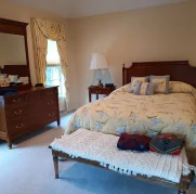 Tidy and clean bedroom with a freshly vacuumed carpet after a routine clean.