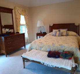 Tidy and clean bedroom with a freshly vacuumed carpet after a routine clean.