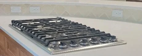 Clean granite countertop with a gas stove top after a routine clean.