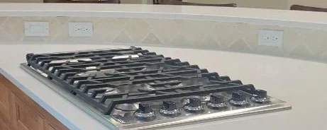 Clean granite countertop with a gas stove top after a routine clean.