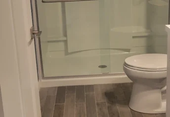 Sparkling standing shower doors in a recently deep clean modern bathroom.