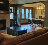 Tidy living room after a routine cleaning with a brick fire place and leather couch.