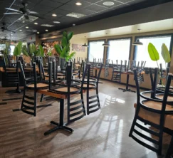 Clean restaurant dining room floor with chairs on tables after routine clean.