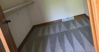 Clean vacuum lines in an empty closet after a move-out deep clean.