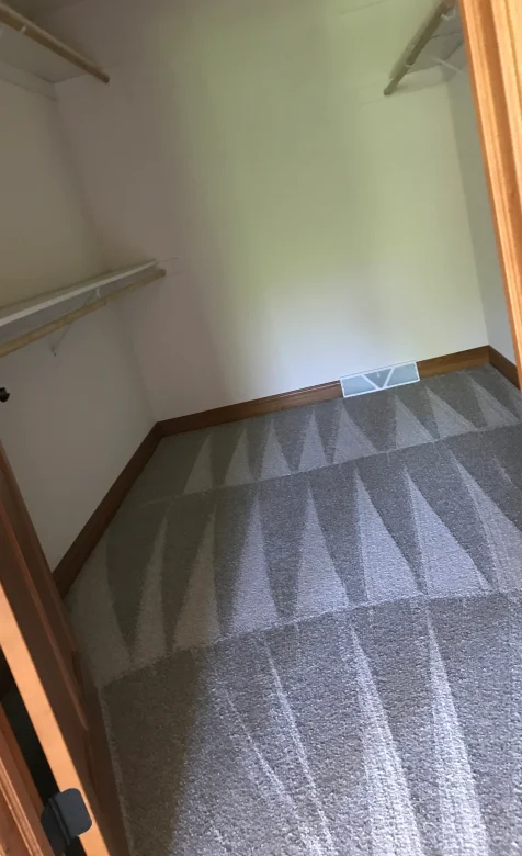 Clean vacuum lines in an empty closet after a move-out deep clean.